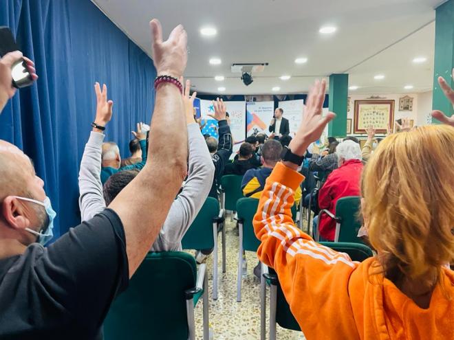 Los asistentes a la charla aplauden en lenguaje de signos.