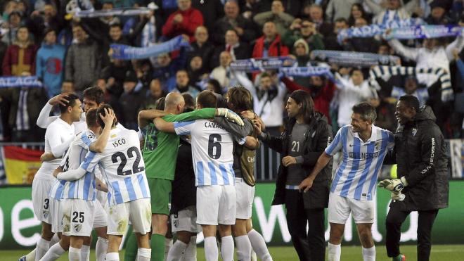 Jugadores del Málaga se abrazan tras un partido en la temporada de la Champions.