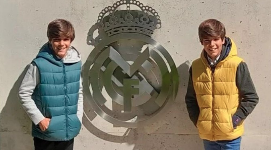 Jacobo y Nico Alfonso posan delante del escudo del Real Madrid.