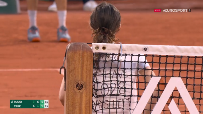 Una persona se encadena a la red en Roland Garros.
