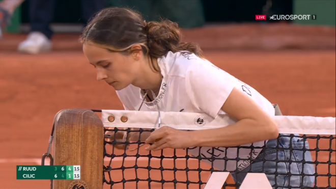 Una persona se encadena a la red en Roland Garros.