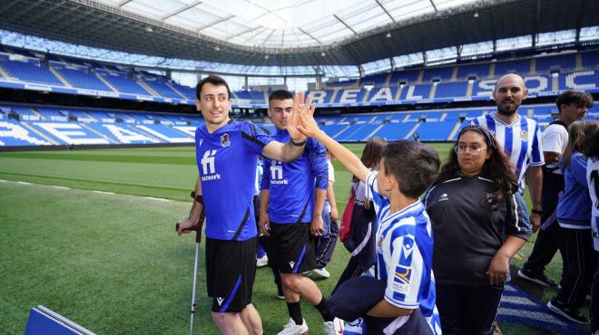 Mikel Oyarzabal y Ander Barrenetxea saludan a unos jóvenes aficionados en el Reale Arena (Foto: Real Sociedad).