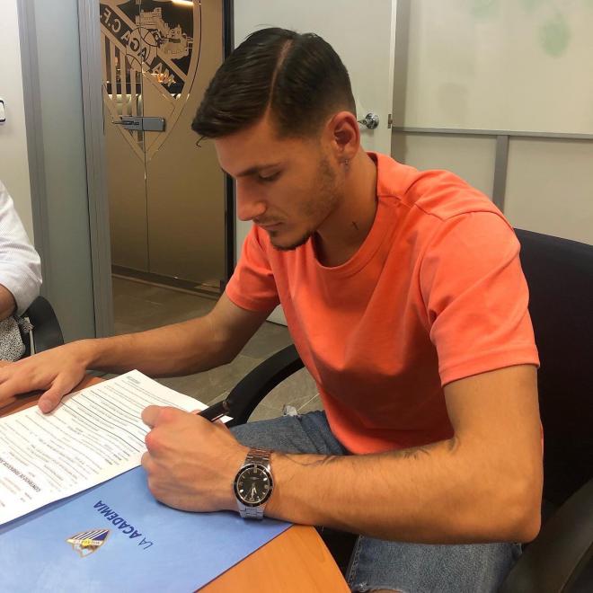 Cristian Gutiérrez, firmando su contrato con el Málaga (Foto: @TImplica).