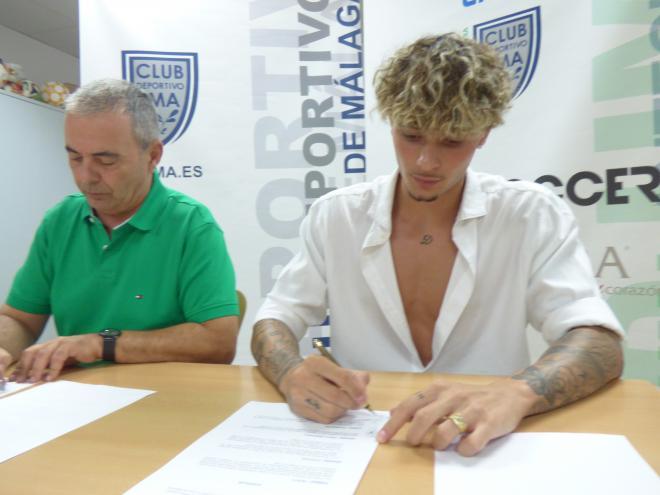 Daniel Fernández firmando el contrato con el BeSoccer UMA Antequera.
