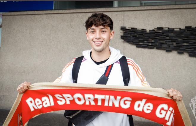 Jordán Carrillo posa con la bufanda del Sporting en su llegada a Asturias.