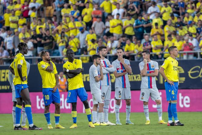 Los jugadores de Cádiz y Barcelona, mientras atendían al aficionado (Foto: EFE).