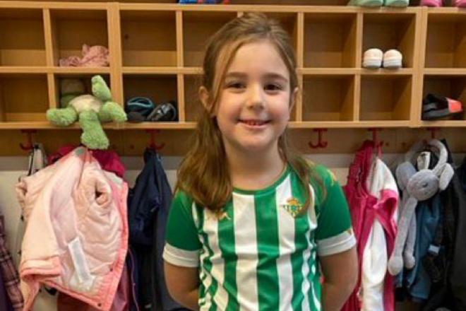 Greta posa orgullosa con su camiseta del Betis en su colegio de Alemania.