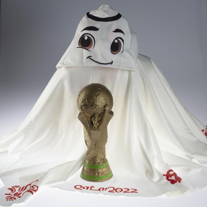 La'eeb, la mascota del Mundial de Qatar con la Copa del Mundo y la pelota (Foto: Cordon Press).