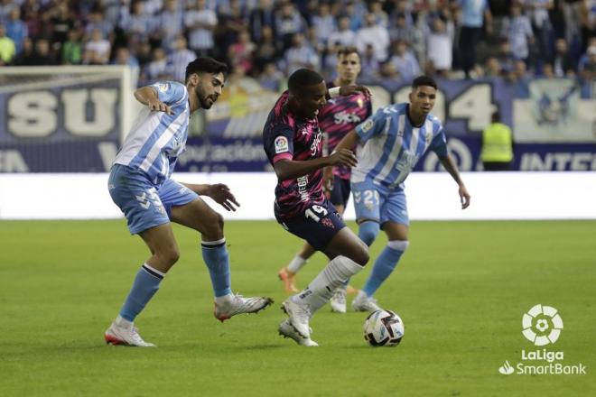 Juan Otero protege ante Juande en el Málaga-Sporting (Foto: LaLiga).