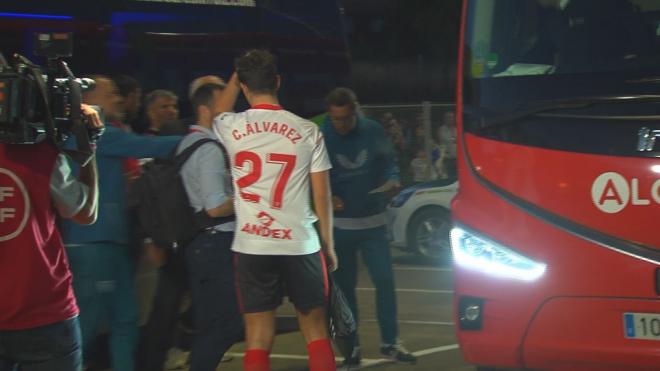 El jugador del Velarde espera cerca del autobús del Sevilla para recibir la bandera firmada por todos