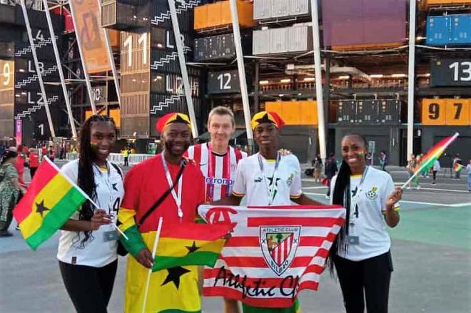 El periodista Paul Giblin luce bandera y una camiseta del Athletic Club con la afición de Ghana en Qatar.