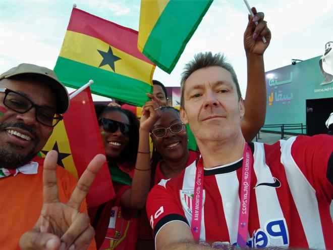 El periodista Paul Giblin luce su camiseta del Athletic con la afición de Ghana en Qatar.