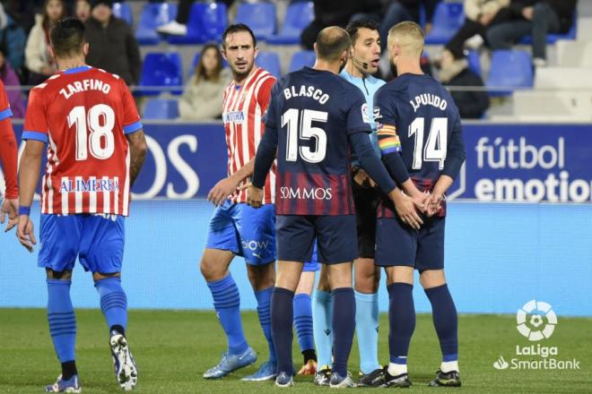 Izquierdoz observa al árbitro y Pulido durante el Huesca-Sporting (Foto: LaLiga).