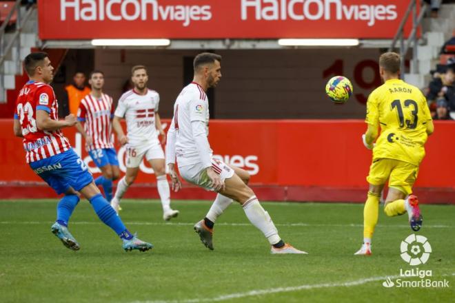 Aarón Escandell atrapa ante Djuka en el Sporting-Cartagena (foto: LaLiga).