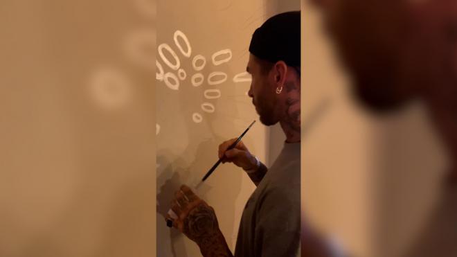 Sergio Ramos mostrando sus dotes como pintor sobre una pared.