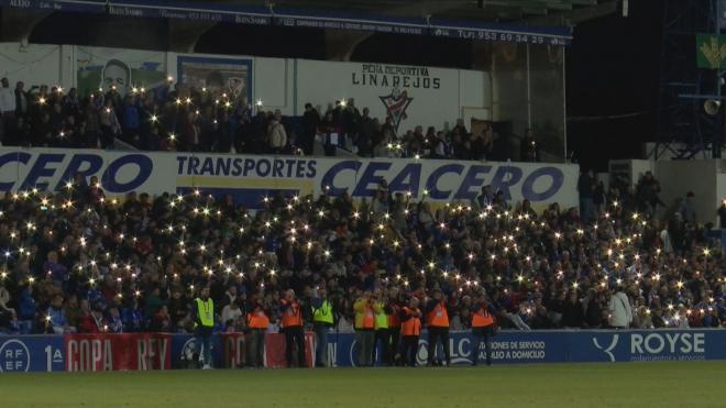 La grada del Linarejos enciende luces blancas al ritmo del 'Quédate'