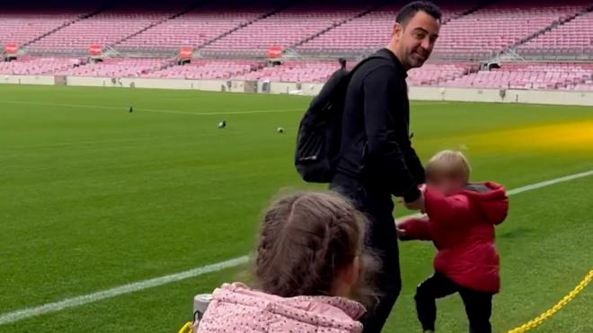 Xavi Hernández, en el césped del Camp Nou acompañado de sus hijos.