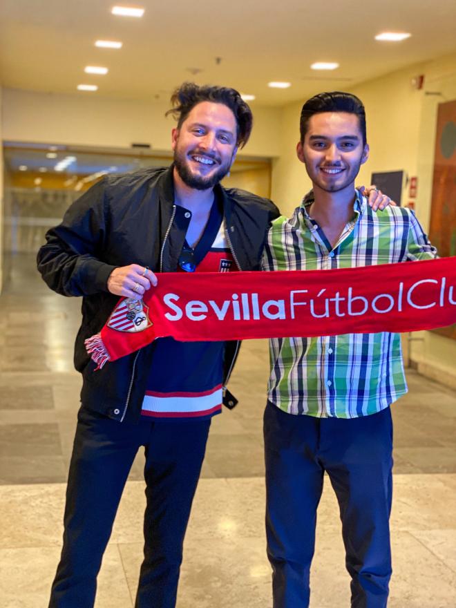 Un sevillista de México posa con una bufanda del Sevilla junto a Manuel Carrasco.