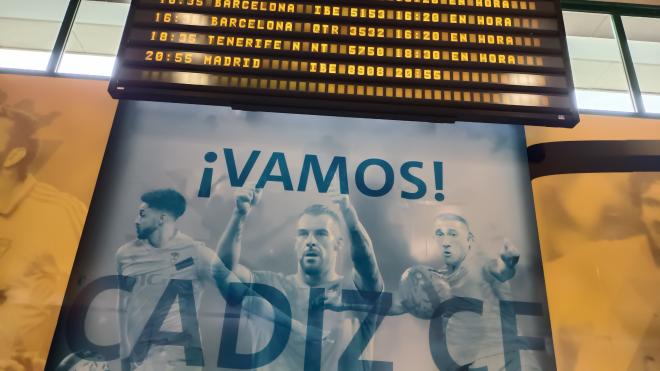 Un cartel del Cádiz bajo los paneles de los horarios de llegada en el Aeropuerto de Jerez.