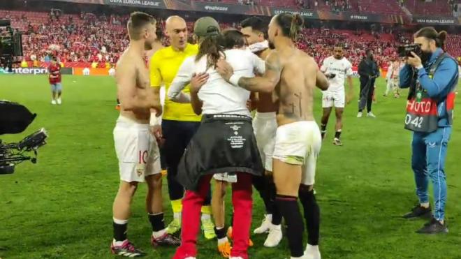Los jugadores del Sevilla, abrazando al hermano de Gudelj. (@Curro_GL_)