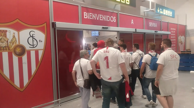 Sevillistas atraviesan la puerta de salida del Aeropuerto de Sevilla.
