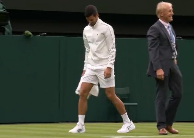 Djokovic con la toalla secando la pista en Wimbledon