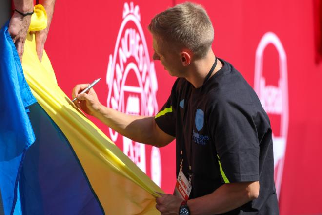 Zinchenko firma una bandera de Ucrania durante la gira del Arsenal en EE.UU. (Cordon Press)