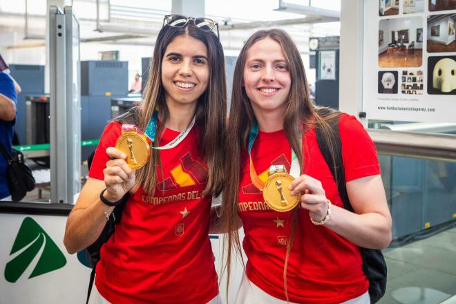 Alba Redondo y Enith Salón muestran sus medallas como campeonas del mundo a su llegada a Valencia.