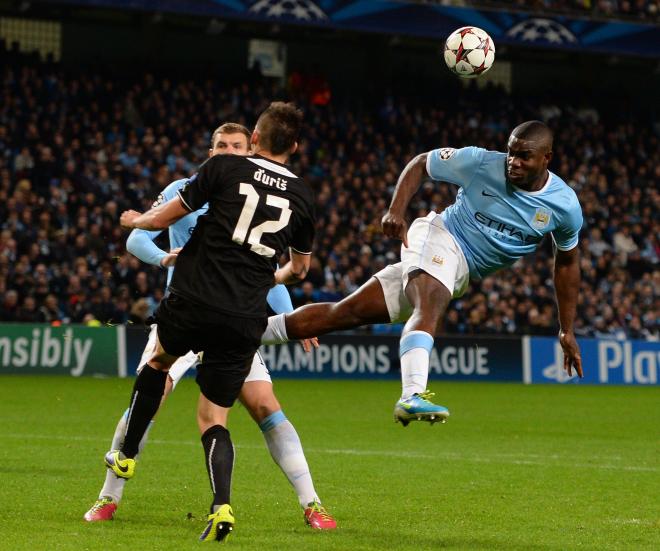 Micah Richards rematando un balón en la Champions League con el Manchester City.
