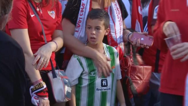Un pequeño aficionado del Betis, entre la afición del Sevilla.
