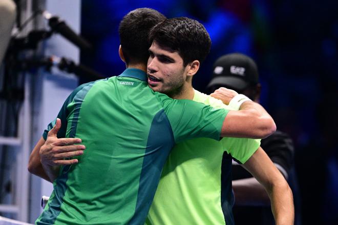 Alcaraz y Djokovic se abrazan tras un partido.