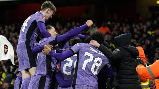 Dos aficionados del Liverpool saltan a celebrar el gol con los jugadores