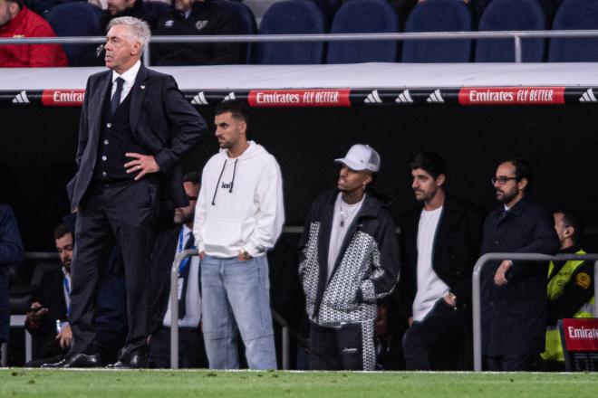 Ceballos, Militao y Courtois viendo un partido con Ancelotti del Real Madrid desde el banquillo (Foto: Cordon Press).