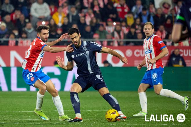 Mikel Merino, controla un balón rodeado de jugadores en el Girona - Real Sociedad (Foto: LALIGA).