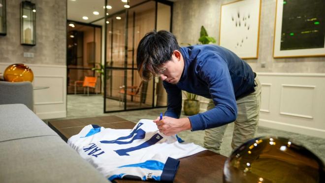 Take Kubo firma su camiseta tras renovar con la Real (Foto: Real Sociedad).