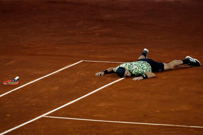 El tenista argentino Federico Coria se cae al alcanzar una bola frente al chileno Nicolás Jarry, d
