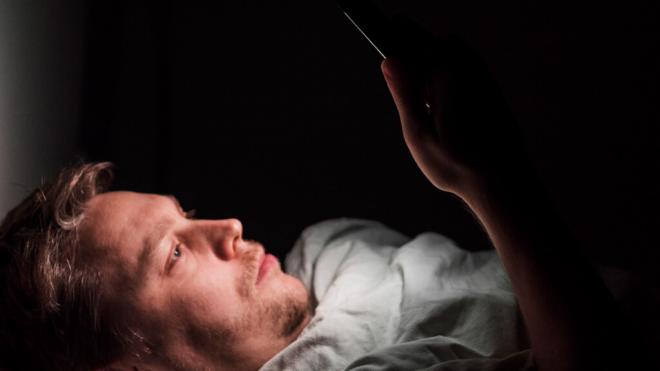 Hombre con el móvil en la cama antes de acostarse