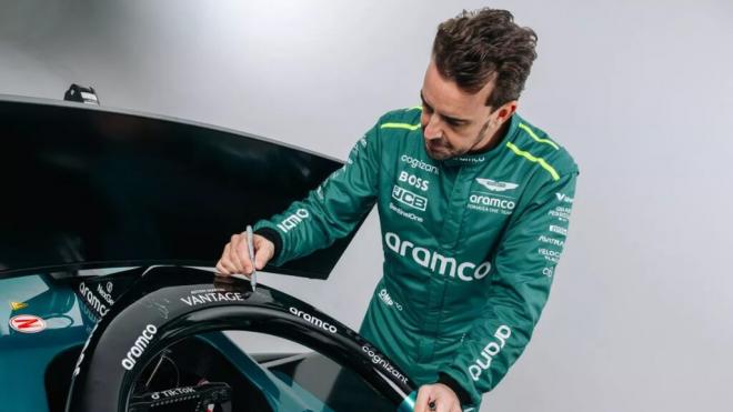 Fernando Alonso, firmando el simulador que se va a subastar (Foto: Aston Martin).