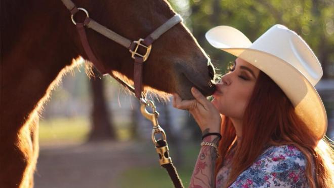 Elena Larrea dando un beso a su caballo Mila en una de sus publicaciones de Instagram (@elenaypunto