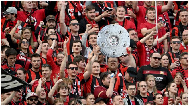Los aficionados del Bayer Leverkusen, con una imitación del trofeo de la Bundesliga (foto: Cordon