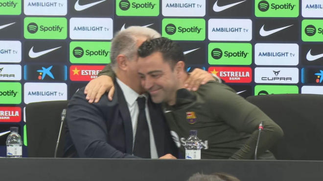 Xavi Hernández y Joan Laporta abrazándose en rueda de prensa