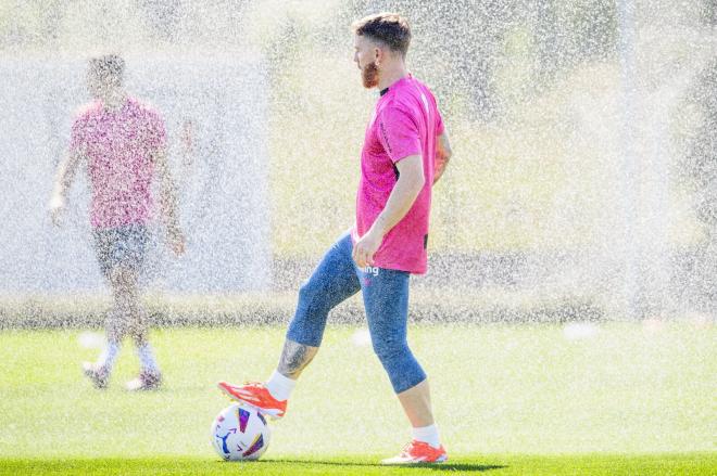 Bella foto del capitán Iker Muniain con un balón y una cortina de agua en Lezama (Foto: Athletic Club).