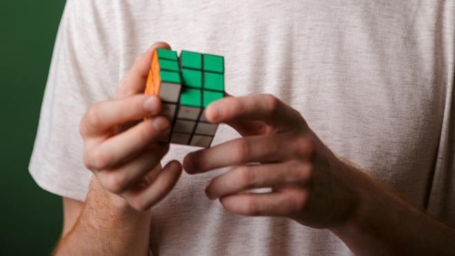 Persona haciendo un cubo de Rubik (Foto: Freepik)