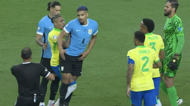 Raphinha empuja a Ronald Araujo en el Uruguay-Brasil de la Copa América.