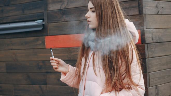 Chica joven vapeando en la calle (Foto: Freepik)