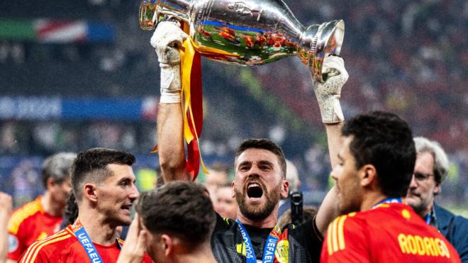 El portero del Athletic Club Unai Simón levantando el trofeo de la Eurocopa 2024, en Berlín, junto a Vivian y Rodri (Cordon Press).