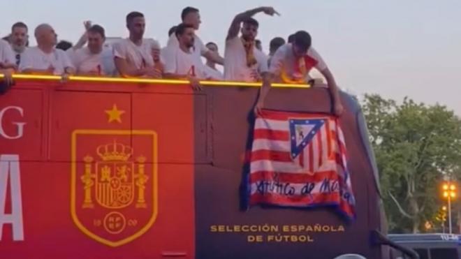 Álvaro Morata posando con la bandera del Atleti durante el recorrido (Redes sociales)