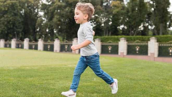 Niño corriendo por el césped de un parque (Foto: Freepik)