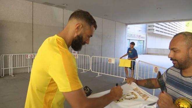 Karim Benzema firma una camiseta del Real Madrid