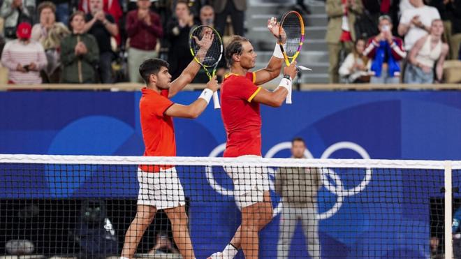 Carlos Alcaraz y Rafael Nadal saludando al público durante el primer partido de dobles de los JJOO de París 2024 (Fuente: Europa Press)